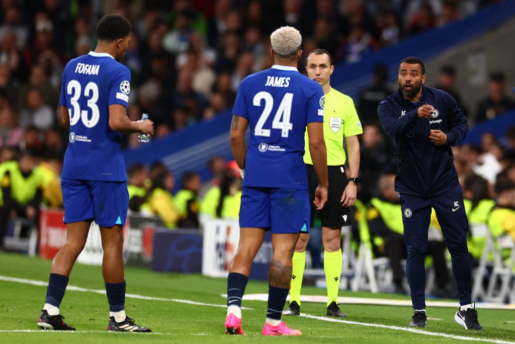 Chelsea coach Ashley Cole makes a point to Reece James and Wesley Fofana during the UEFA Champions League quarterfinal first leg match between Real...