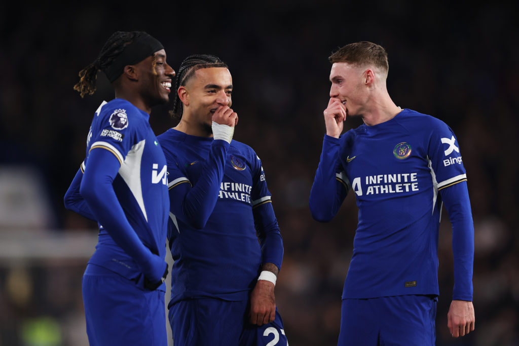 Cole Palmer of Chelsea (R) interacts with teammates Noni Madueke (L) and Malo Gusto (C) during the Premier League match between Chelsea FC and Ever...