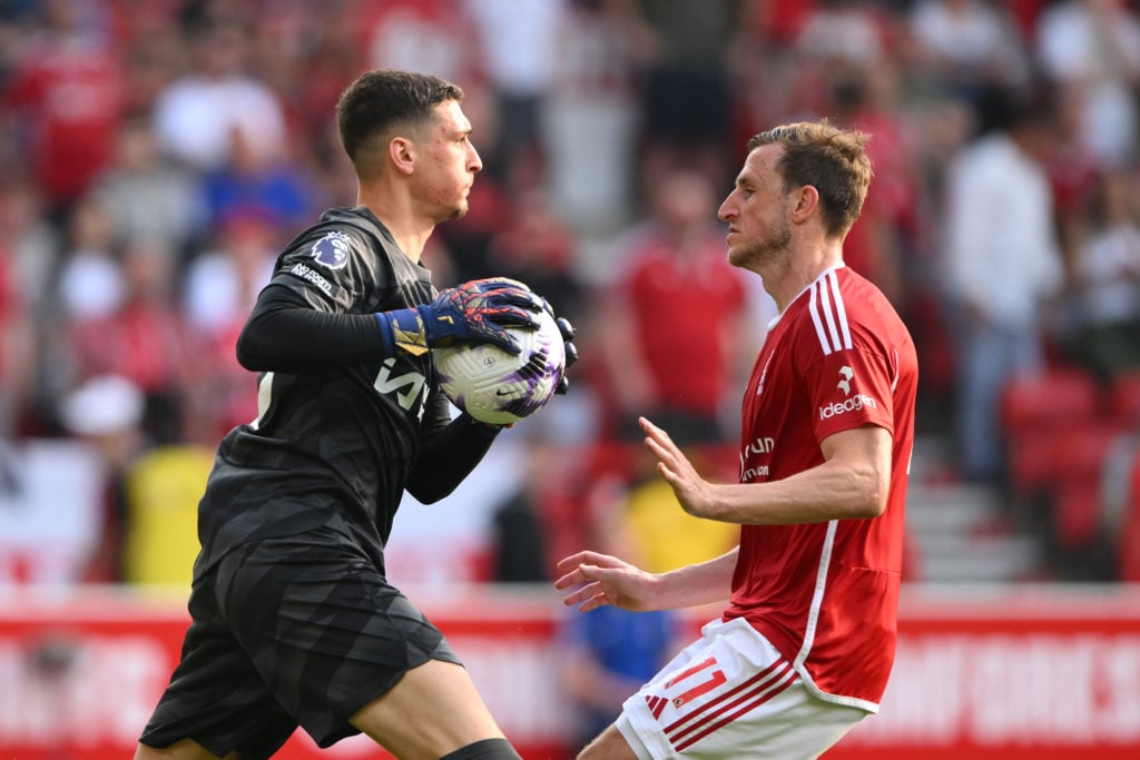 Djordje Petrovic of Chelsea is under pressure from Chris Wood of Nottingham Forest during the Premier League match between Nottingham Forest and Ch...