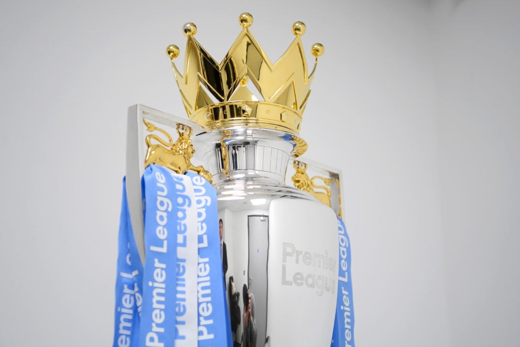 Ribbons in the colours of Manchester City are placed onto the Premier League trophy after their side finished the 2021/2022 season as champions aft...