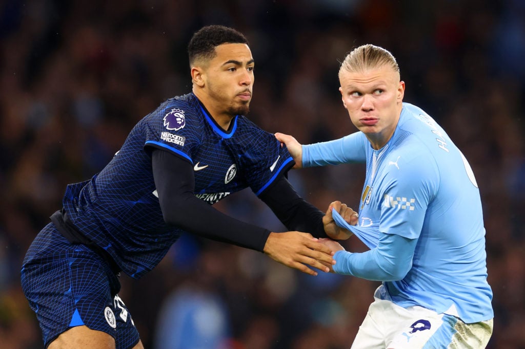 Erling Haaland of Manchester City grapples with Levi Colwill of Chelsea during the Premier League match between Manchester City and Chelsea FC at E...