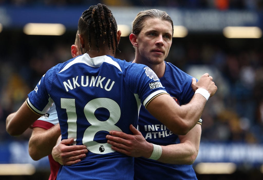 Chelsea's French striker #18 Christopher Nkunku (C) embraces Chelsea's English midfielder #23 Conor Gallagher following the English Premier League ...
