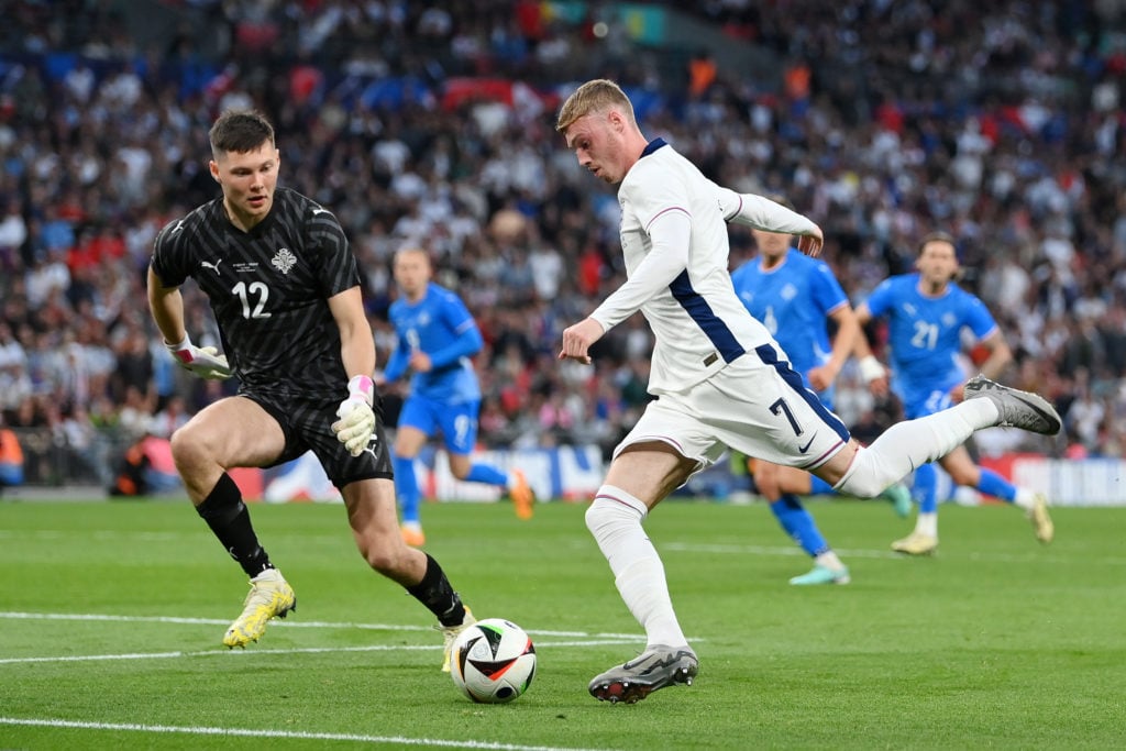 Cole Palmer of England runs with the ball under pressure from Hakon Rafn Valdimarsson of Iceland during the international friendly match between En...