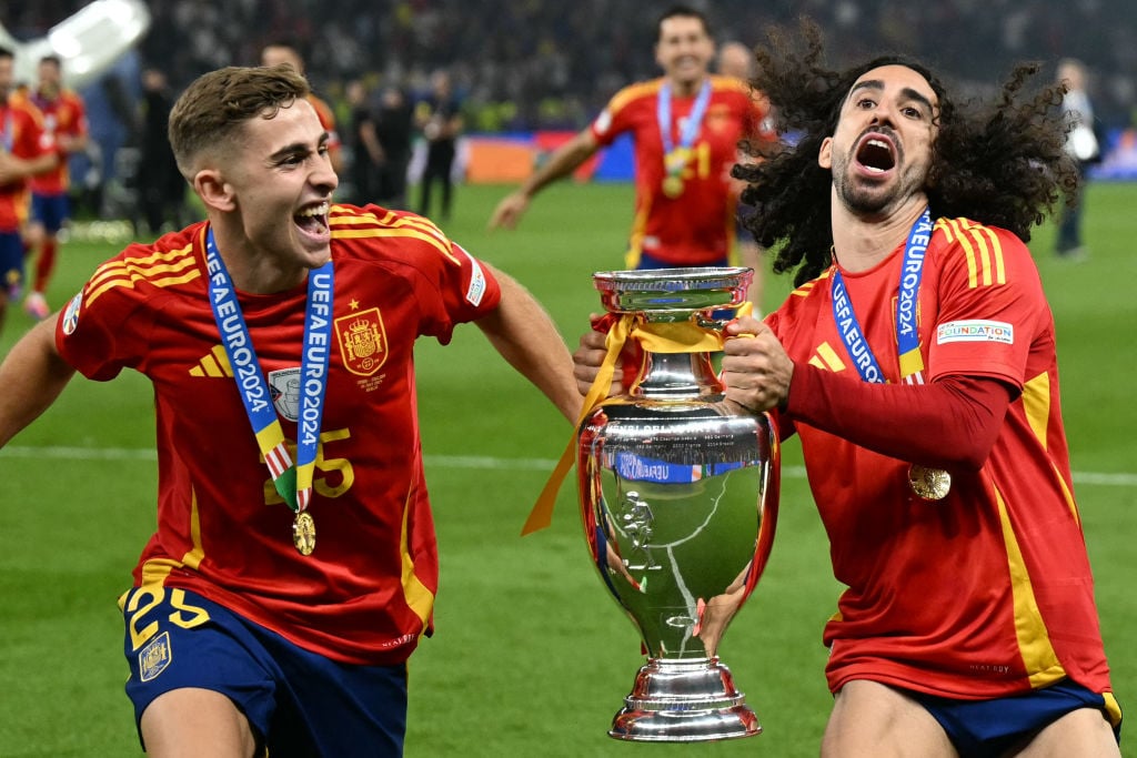 Spain's defender #24 Marc Cucurella (R) and Spain's forward #25 Fermin Lopez run with the trophy during a lap of honor after winning the UEFA Euro ...