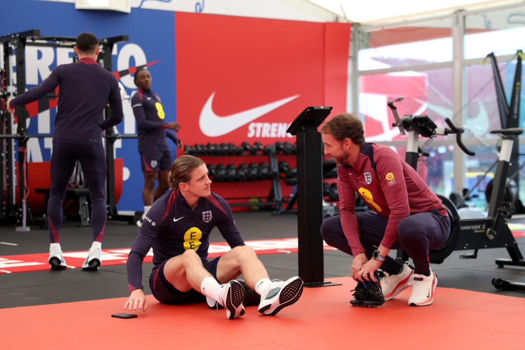 Gareth Southgate, Manager of England men's senior team, talks to Conor Gallagher of England in the gym at Spa & Golf Resort Weimarer Land on Ju...
