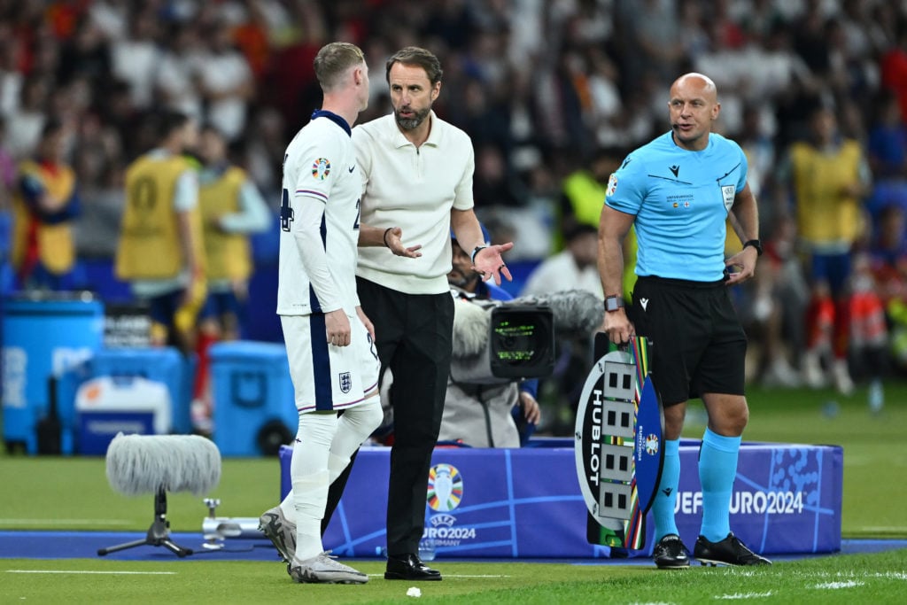 Gareth Southgate, Head Coach of England, speaks with Cole Palmer of England as he prepares to come on as a substitute during the UEFA EURO 2024 fin...