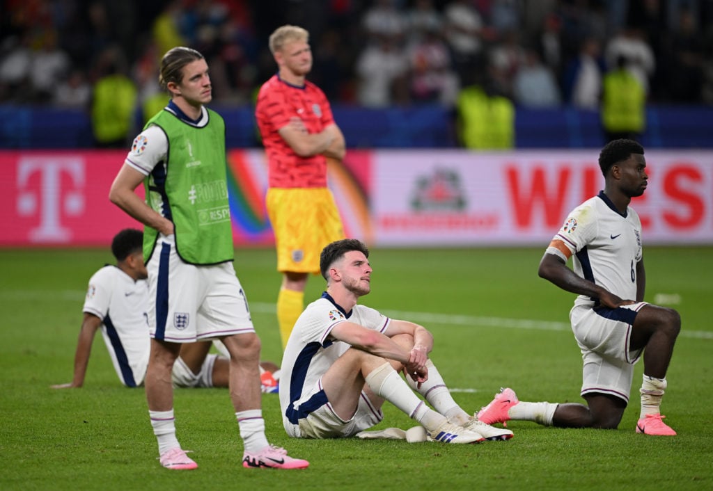 Conor Gallagher, Declan Rice and Marc Guehi of England look dejected as players of Spain (not pictured) celebrate with the UEFA Euro 2024 Henri Del...