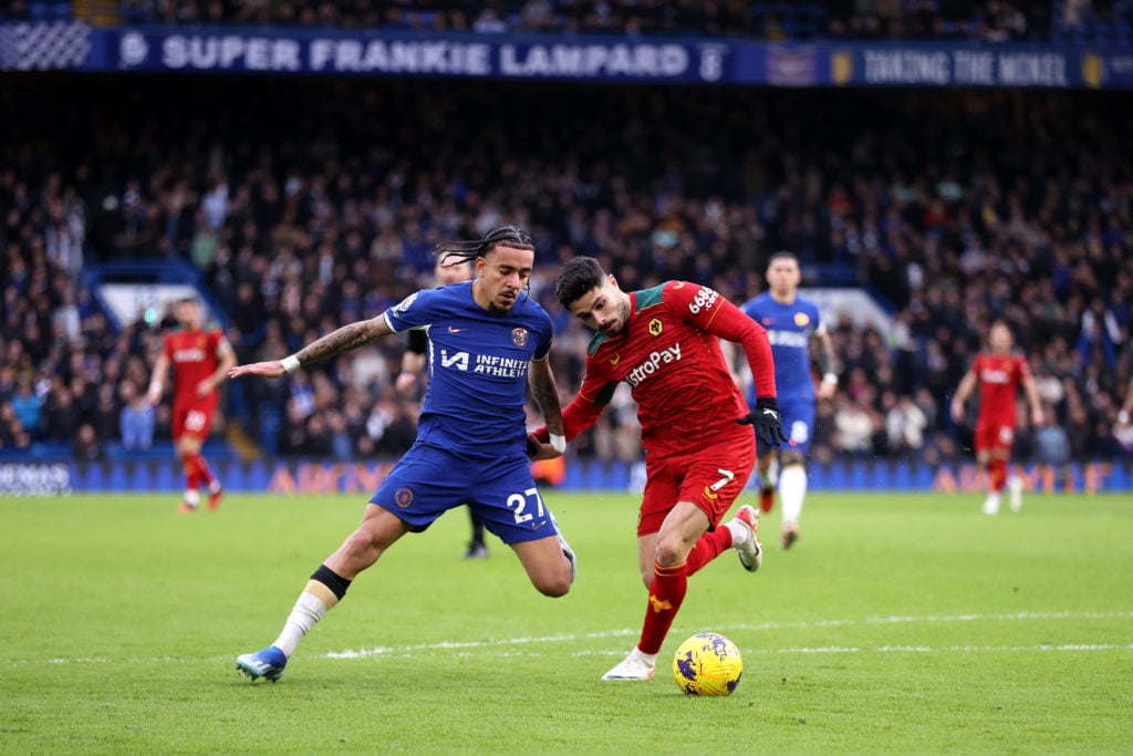 Malo Gusto of Chelsea is closed down by Pedro Neto of Wolves during the Premier League match between Chelsea FC and Wolverhampton Wanderers at Stam...