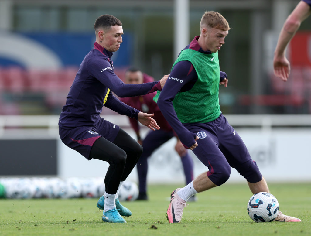 Phil Foden and Cole Palmer of England battle for possession during a training session at St Georges Park on October 08, 2024 in Burton-upon-Trent, ...