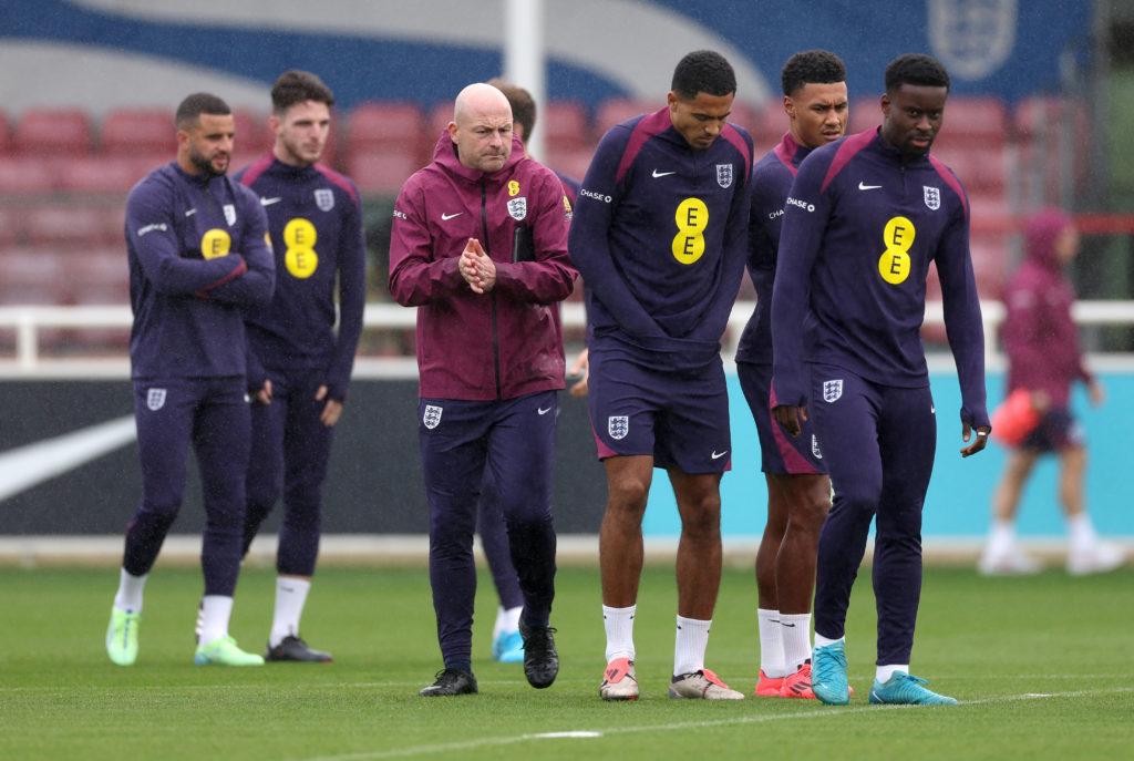 Lee Carsley, Interim Manager of England, walks out alongside Levi Colwill, Ollie Watkins and Marc Guehi during a training session at St Georges Par...