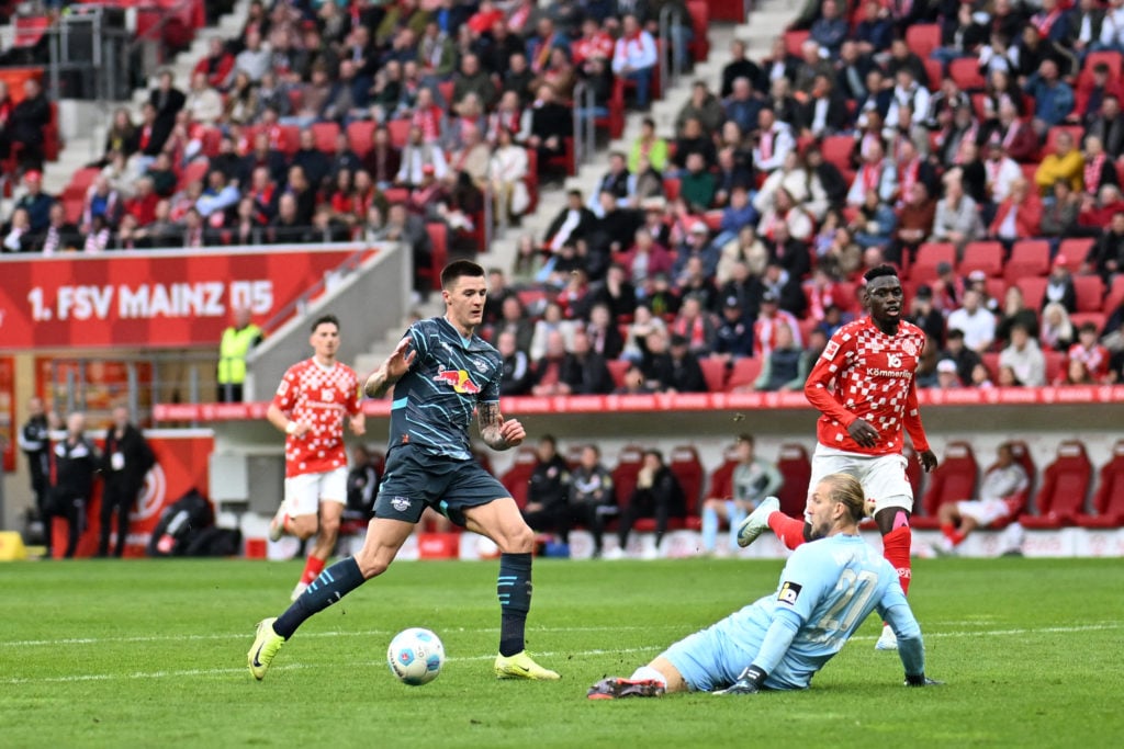 Leipzig's Slovenian forward #30 Benjamin Sesko (L) vies Mainz' German goalkeeper #27 Robin Zentner during the German first division Bundesliga foot...