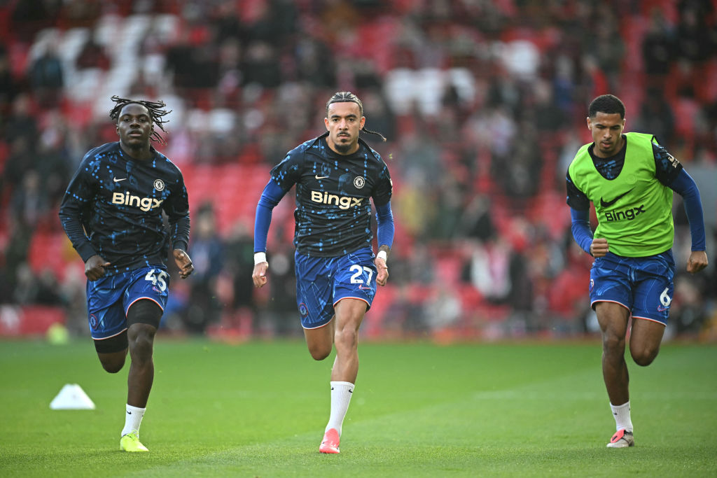 (L-R) Chelsea's Belgian midfielder #45 Romeo Lavia, Chelsea's French defender #27 Malo Gusto and Chelsea's English defender #06 Levi Colwill warm u...