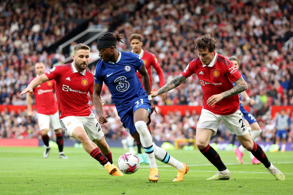 Noni Madueke of Chelsea battles for possession with Luke Shaw and Victor Lindelof of Manchester United during the Premier League match between Manc...