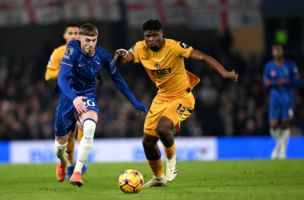 Cole Palmer of Chelsea runs for the ball under pressure from Emmanuel Agbadou of Wolverhampton Wanderers during the Premier League match between C...