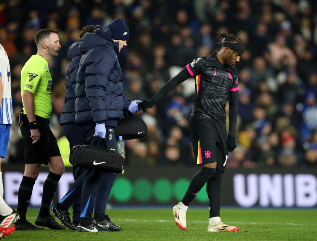 Noni Madueke of Chelsea leaves the field of play following an injury during the Premier League match between Brighton & Hove Albion FC and Chel...