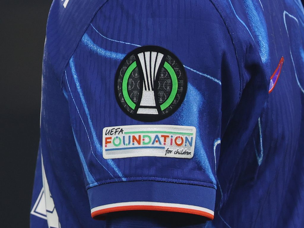 The Conference League logo on a Chelsea shirt