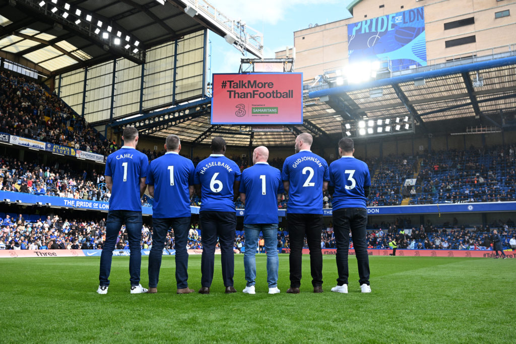 Chelsea Legends, Gary Cahill, Eidur Gudjohnsen and Jimmy Floyd Hasselbaink stand with fans to promote the Samaritans helpline number