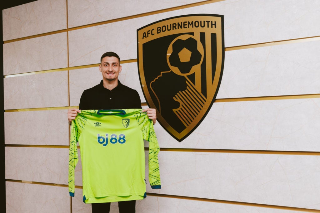 Djordje Petrovic holds up a shirt after officially signing as a new Bournemouth player.