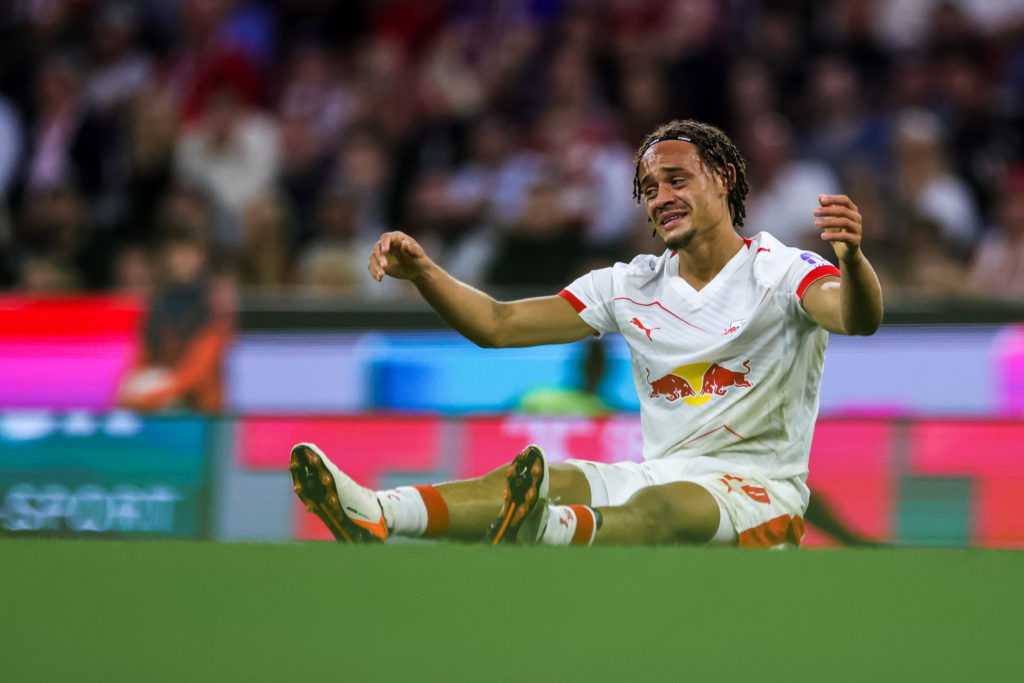 Xavi Simons on the floor looks dejected during RB Leipzig's defeat against Bayern Munich.