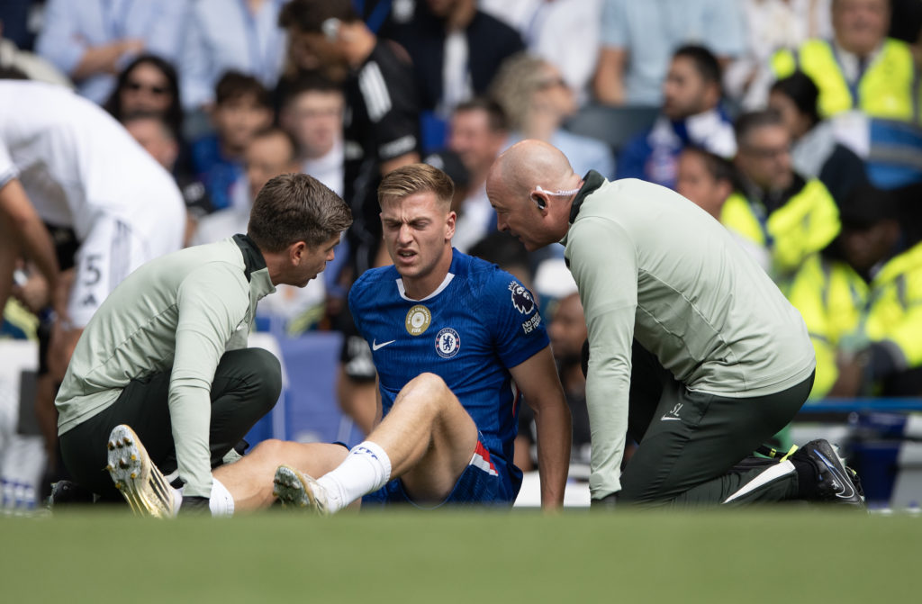 Chelsea striker Liam Delap receives medical attention on the pitch after picking up an injury against Fulham in the Premier League.