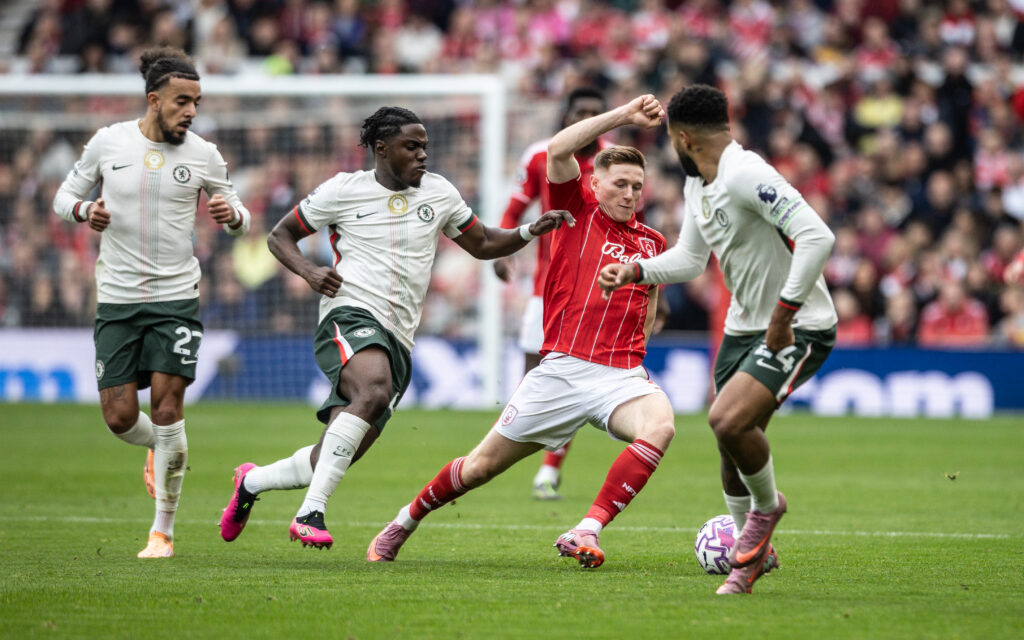 Nottingham Forest's Elliot Anderson dribbling against Chelsea's Reece James, Romeo Lavia and Malo Gusto.