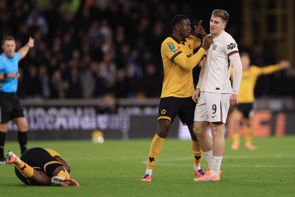 Marshall Munetsi of Wolverhampton Wanderers confronts Liam Delap of Chelsea during the Carabao Cup tie.