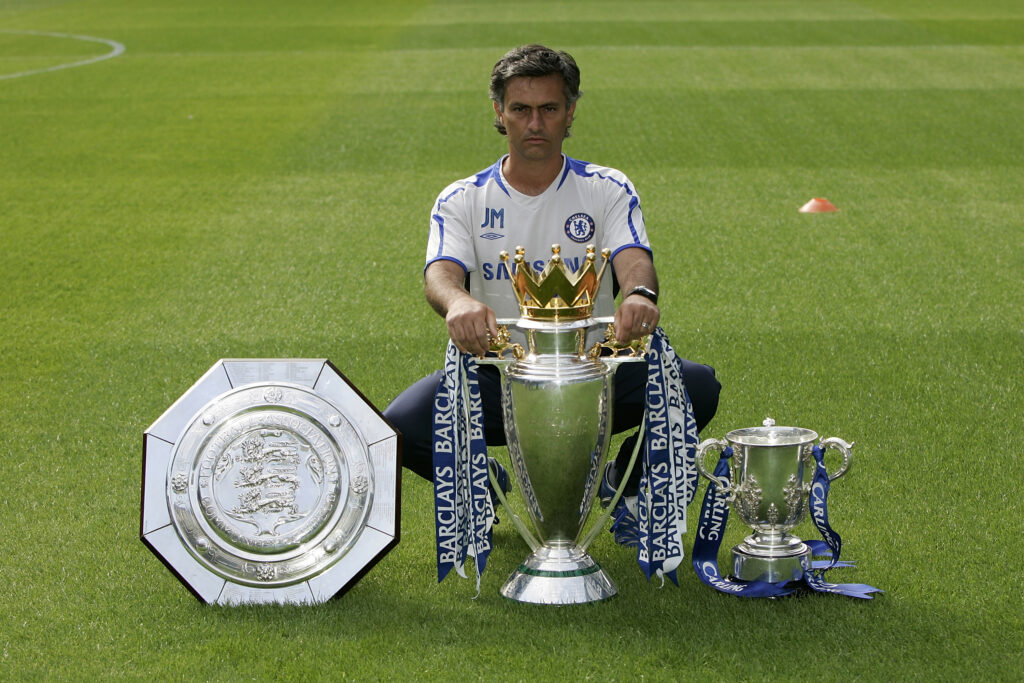 Jose Mourinho poses with three trophies in 2005