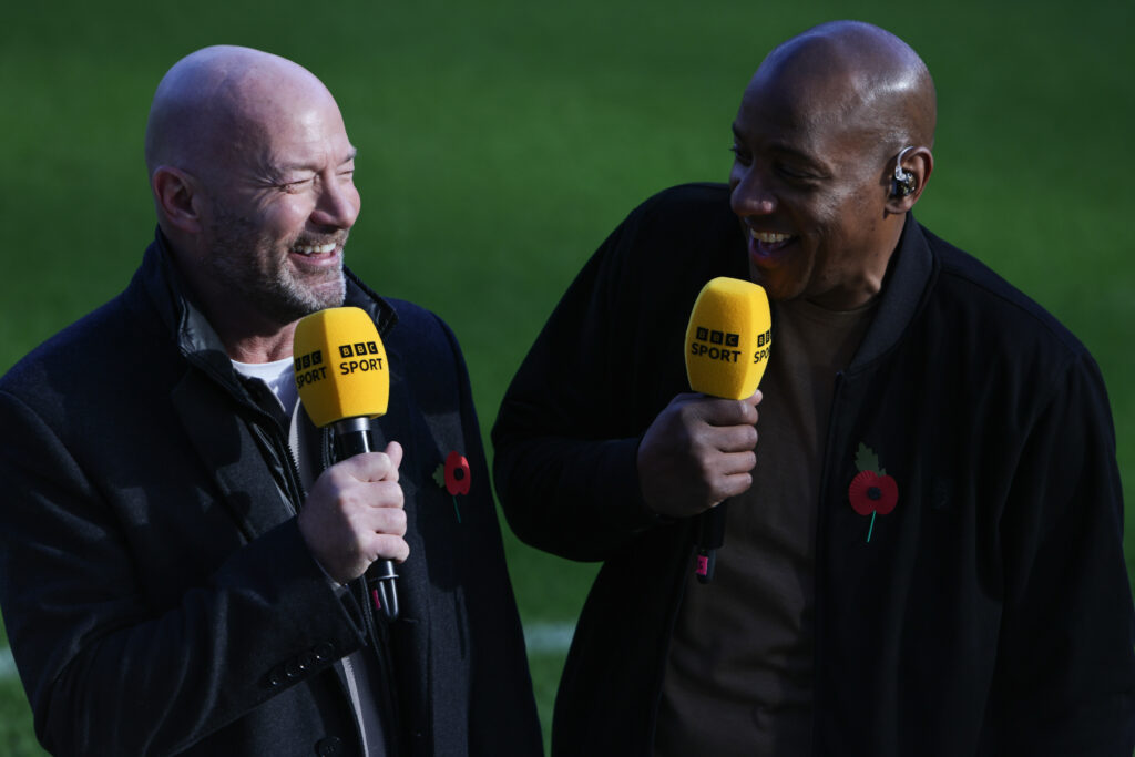 Former footballers Alan Shearer and Dion Dublin smile while holding BBC Sport microphones