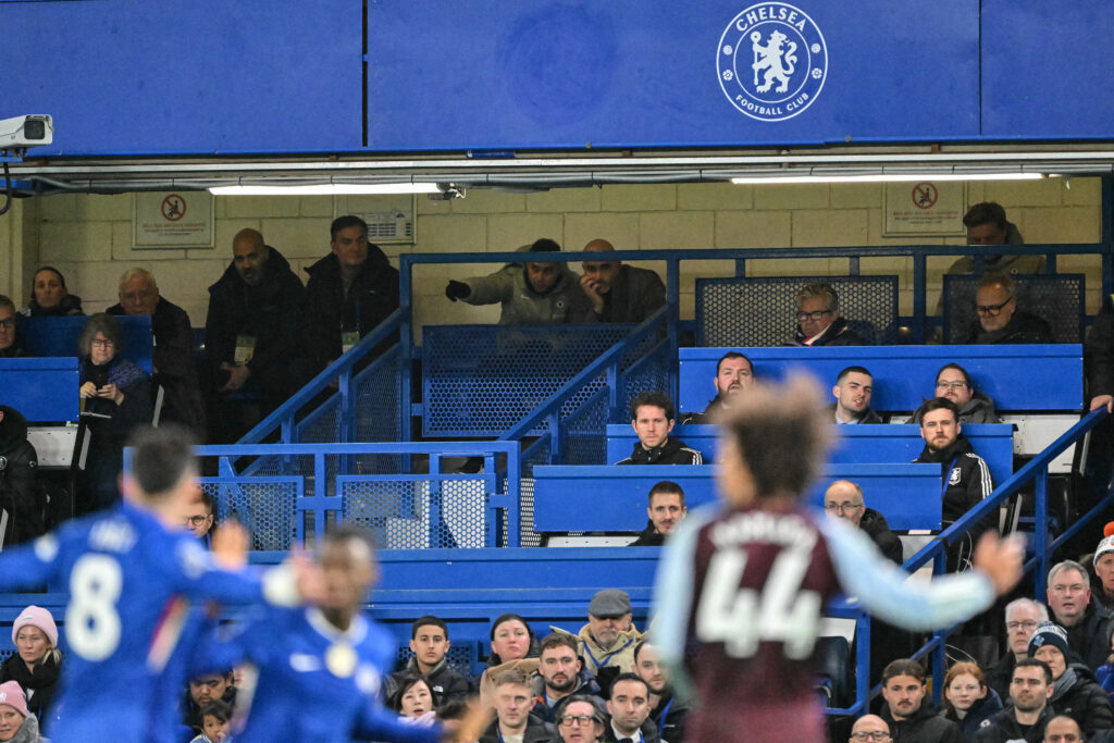 Chelsea's Italian head coach Enzo Maresca (centre R) sits behind the press tribune as he serves a touchline ban