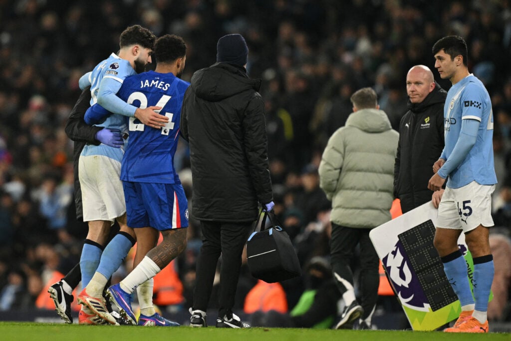 Manchester City's Croatian defender #24 Josko Gvardiol (L) is helped from the pitch by Chelsea's English defender #24 Reece James