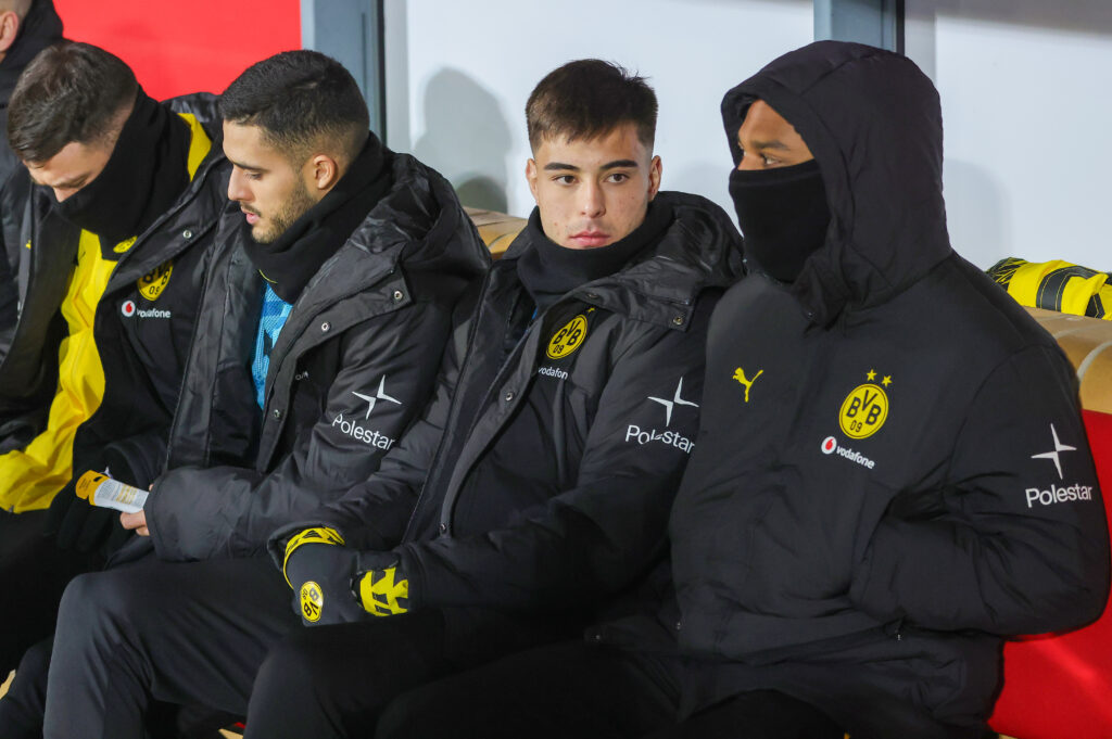 Aaron Anselmino of Borussia Dortmund (C) sits on the bench