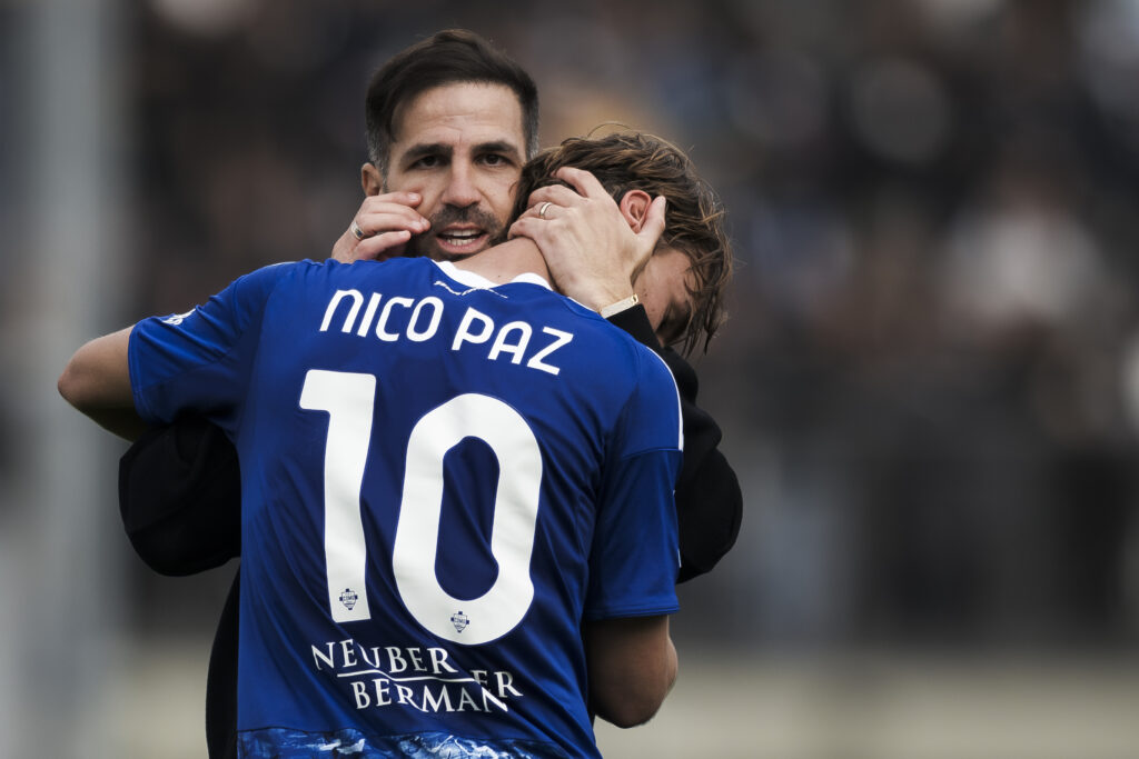 Cesc Fabregas (L), head coach of Como 1907, hugs Nico Paz