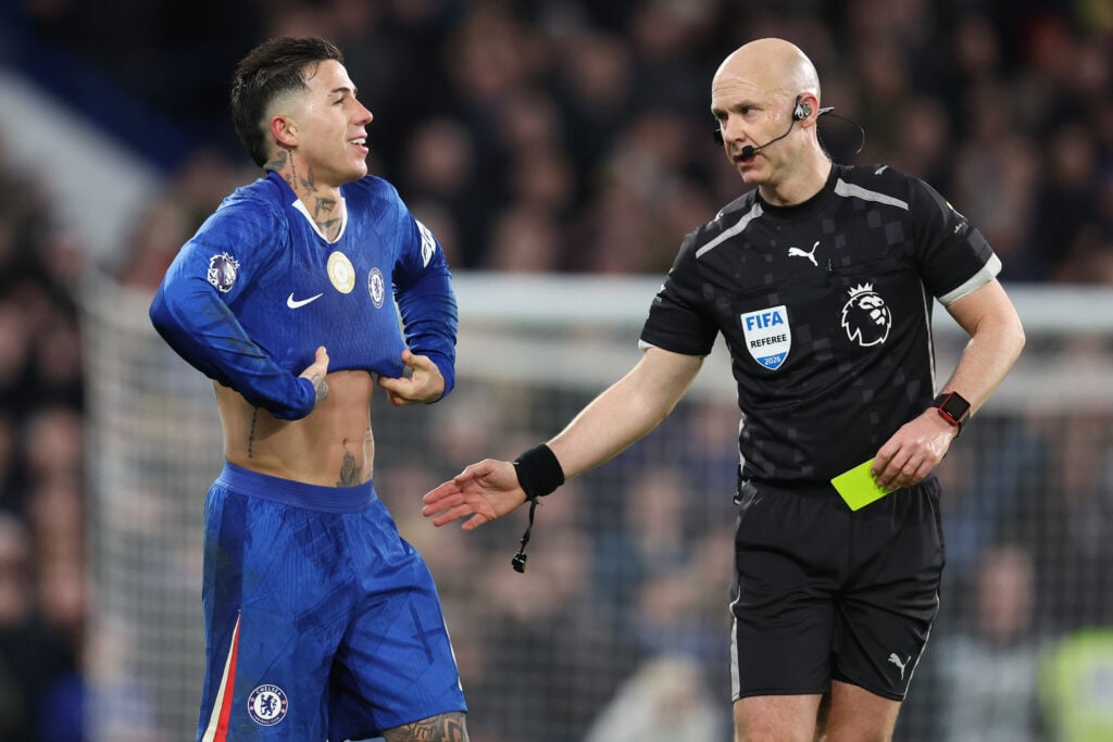 Referee Anthony Taylor issues Enzo Fernandez of Chelsea a yellow card for removing his shirt