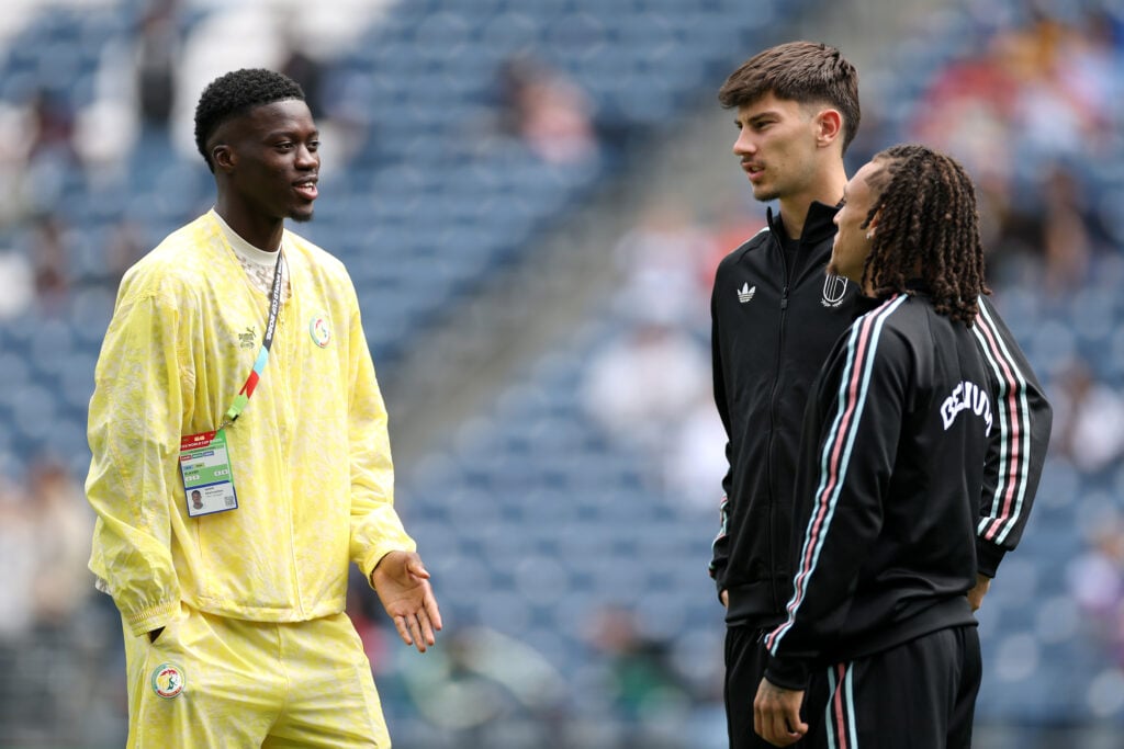 Diego Moreira #19 and Mike Penders #13 of Belgium talk with Mamadou Sarr #2 of Senegal